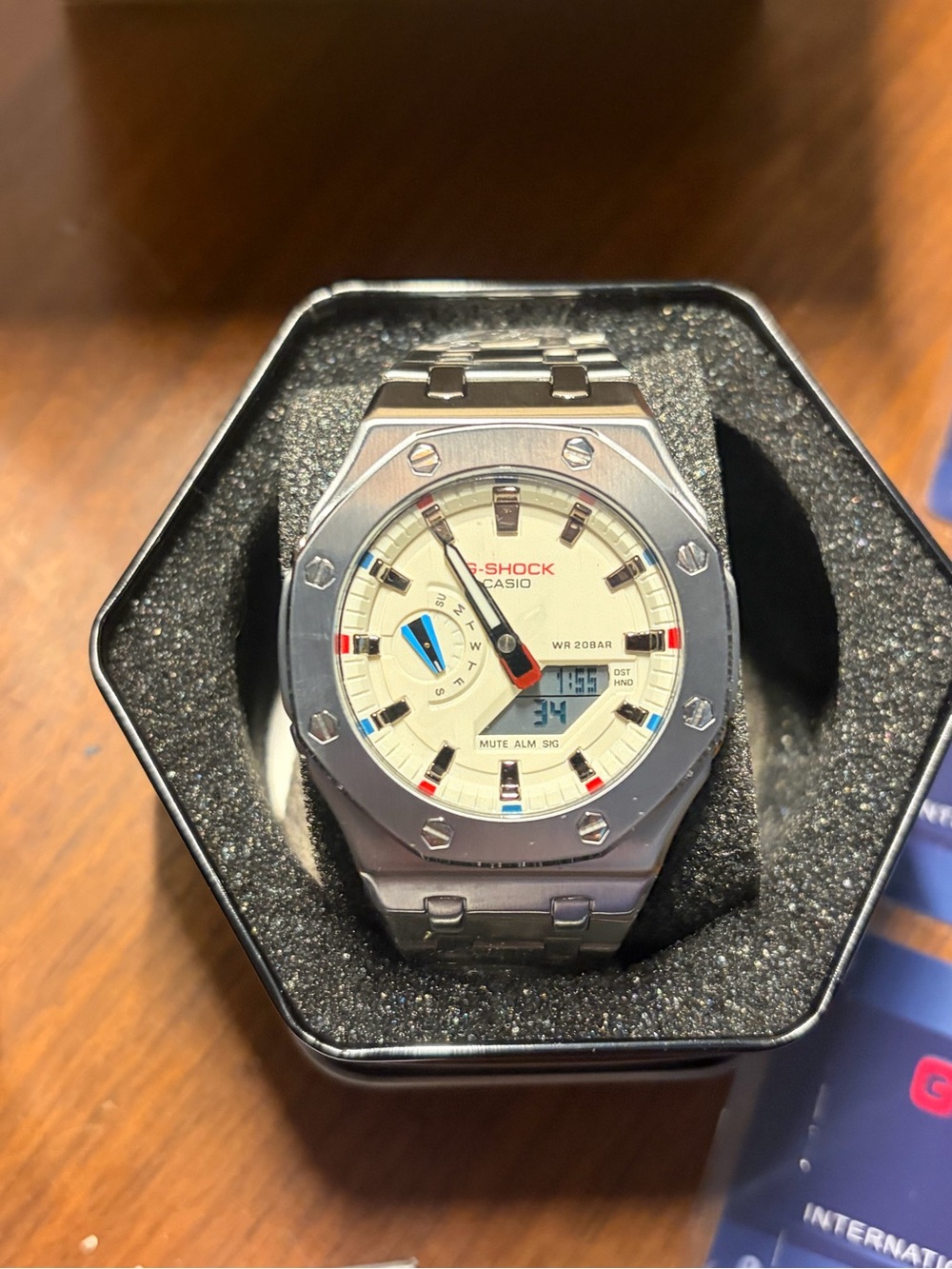 Casio G-Shock Silver Stainless Steel Watch with Cream Dial and Red/Blue Accents
